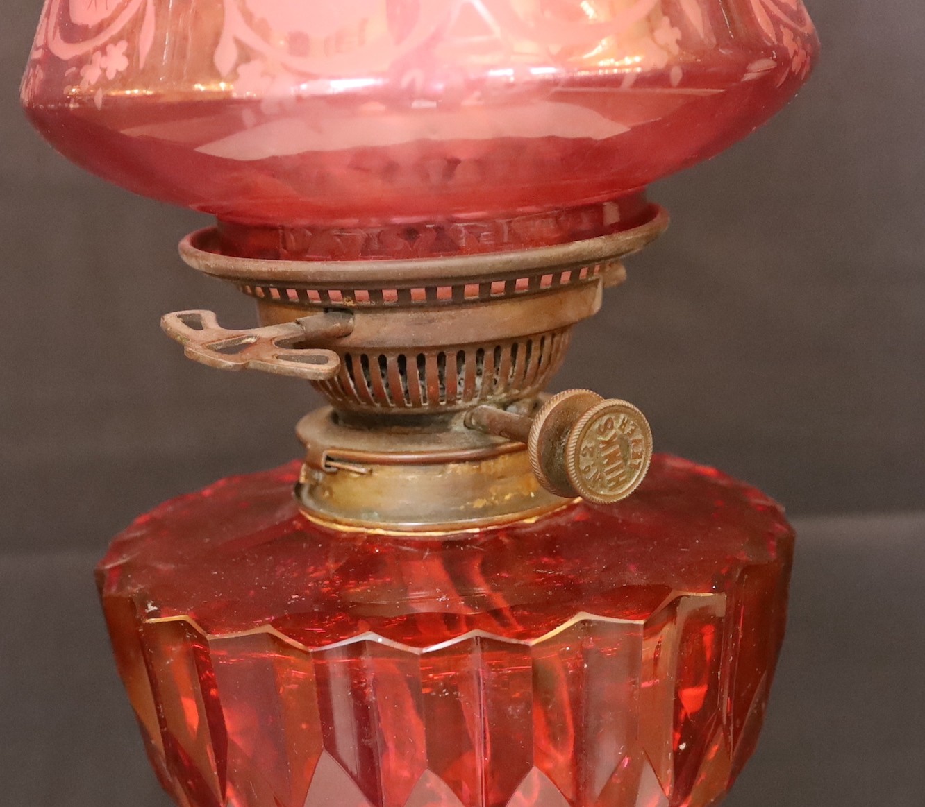 A Victorian lacquered brass fluted column oil lamp with cut ruby glass reservoir, Hinks No2 mechanism, etched cranberry glass shade and flue, height overall 86cm